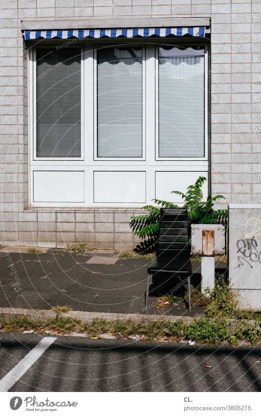 seating Chair Street Window Sun blind Gloomy off Wall (building) Trash Weed Seating Whimsical Bulk rubbish Old Furniture Broken Colour photo Deserted