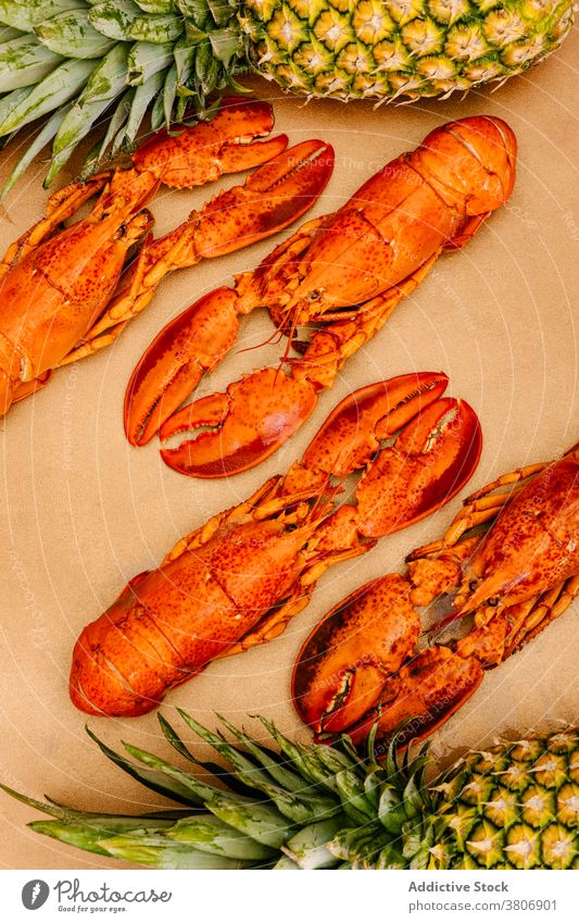 Delicious colorful lobsters near ripe pineapples on table seafood delicious whole exotic shell claw fresh bright organic tropical tasty sweet natural yummy