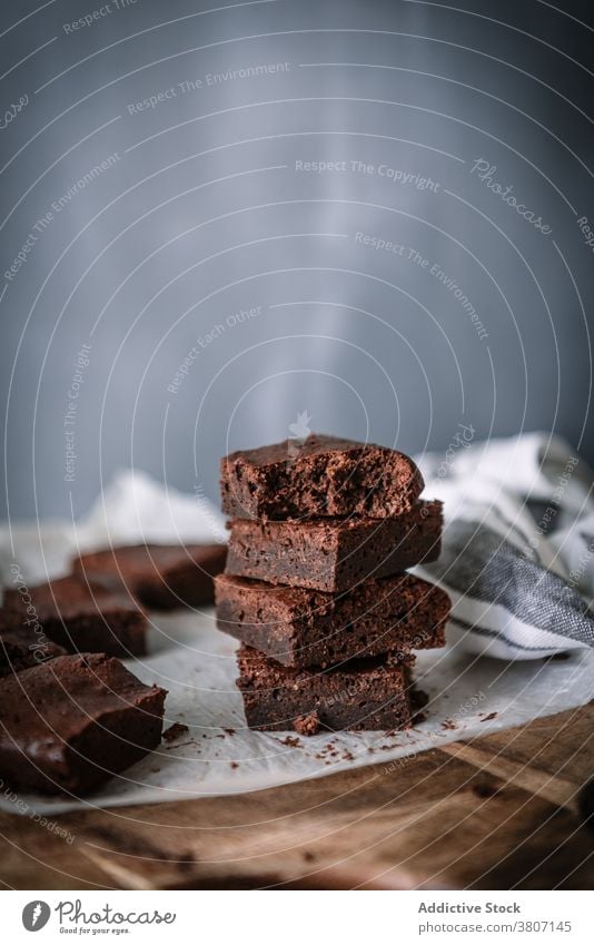 Tasty homemade brownies on parchment in kitchen piece dessert baked treat sweet tasty cutting board chocolate table natural slice product marble yummy flavor