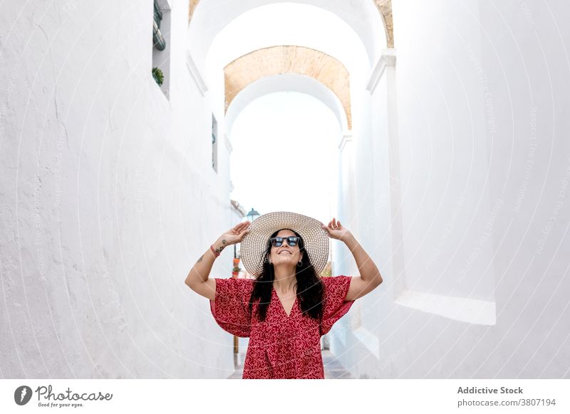 Traveler woman in straw hat exploring White Village in Rhodes traveler arms raised explore architecture house street trip aged summer tourist summertime