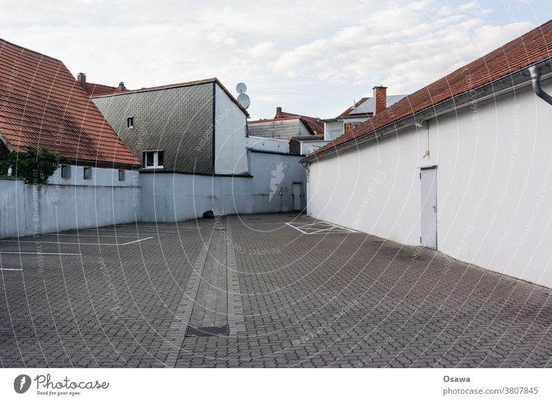 Empty parking space in the backyard of a commercial / residential area Parking lot Backyard Rear side Building houses Town urban pavement void Deserted orphan