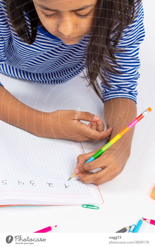 The cute left-handed girl writes with a pencil in her notebook. Enchanting back to school Book Concentrate conceptually Copy area crayons Creativity Draw