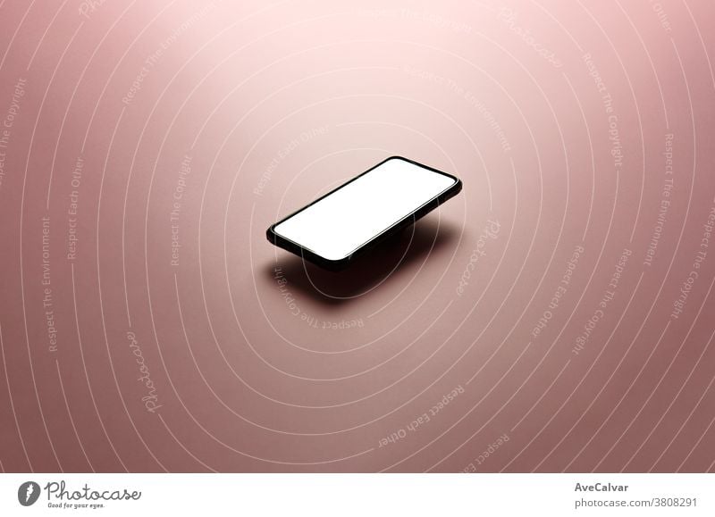 Minimalistic mock up flat image design with a floating mobile phone with copy space and white scree to write over it over a flat pastel pink background