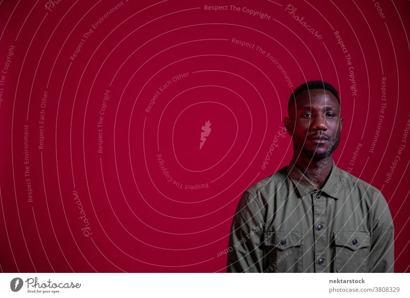 Young Black Man Posing in Studio on Isolated Red Background man black copy space portrait African ethnicity one person male one man only 20-30 years old