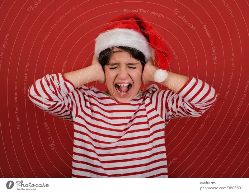 angry kid wearing Santa Claus hat with his hands on his head child christmas santa claus screaming desperate christmas eve furious stressed nervous despair