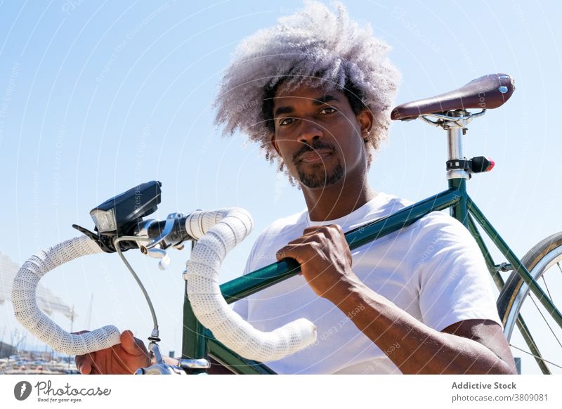 Afro and black man carrying a city bike on his back. Black rider carrying the bike carrying a bike black rider cyclist black cyclist biker afro man transport