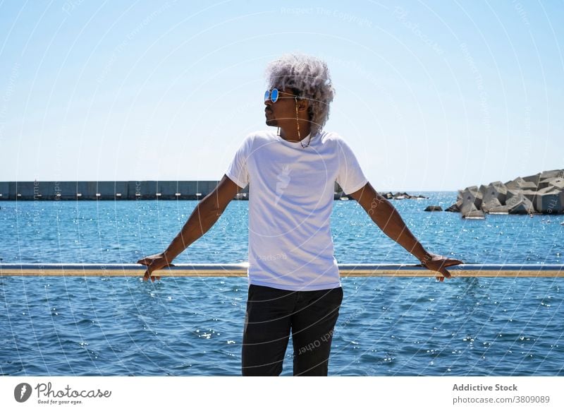 Black man with afro hair relaxing in front of the beach and the black man sea relax on beach summer relaxation afro man calm vacations beachfront reflect