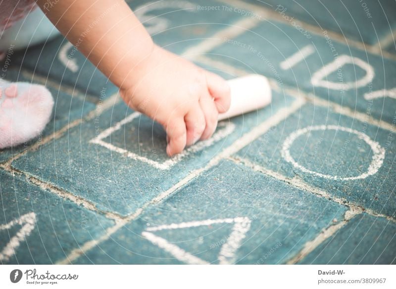 Toddler holds chalk in his hand and paints Chalk Painting (action, artwork) Hand Child Creativity Girl street-painting chalk Employment Infancy fun Draw