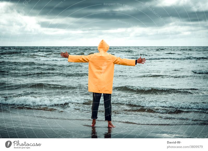 Man in Frisian mink stands with outstretched arms at the sea Ocean ocean Embrace friesennerz Storm Waves Vacation & Travel Water coast Clouds stormy Gigantic