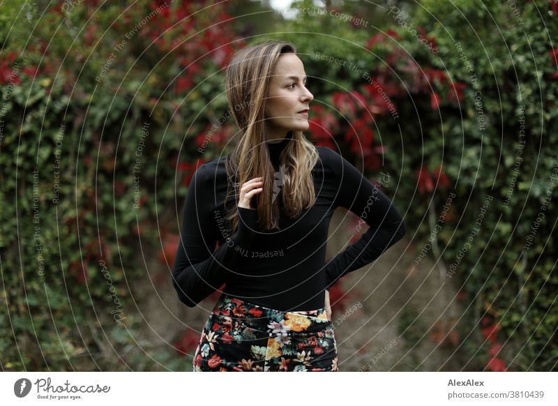 Lateral portrait of a young woman in front of a wall with ivy and wild wine Woman 18 - 30 years pretty fit Slim smart kind Pleasant Attractive Brunette