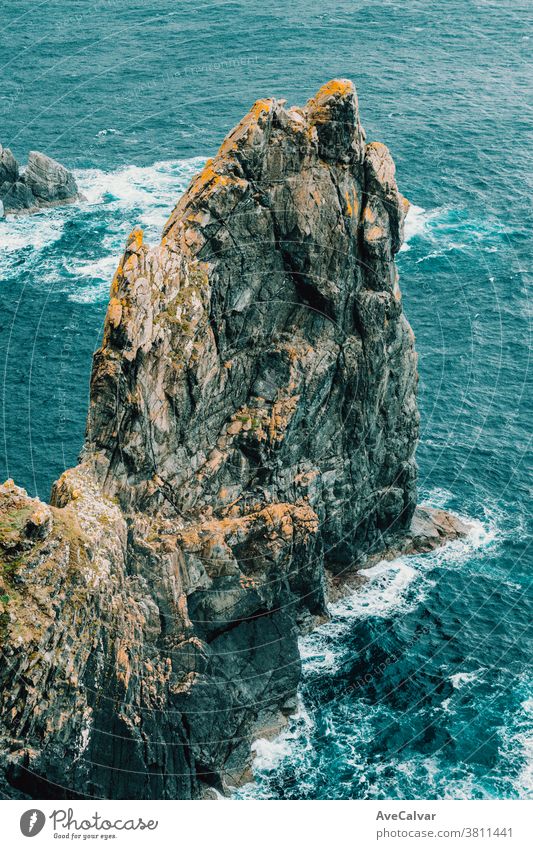 Relaxing close up of a giant stone in the middle of the blue ocean breaking wave horizontal surf awe power spray stormy weather wind crash foam motion no people