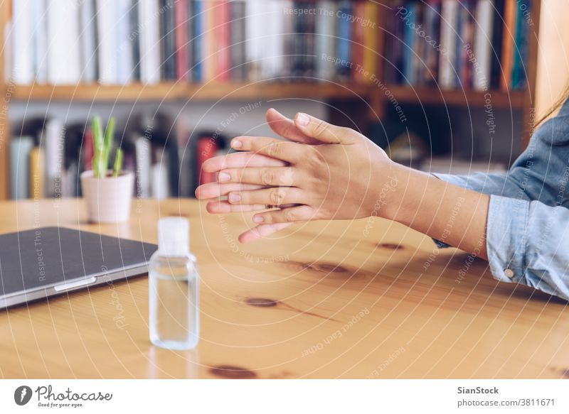 Coronavirus concept. Girl working from home put antiseptic gel on her hands for protection from coronavirus. Global call to stay home. covid quarantine spraying