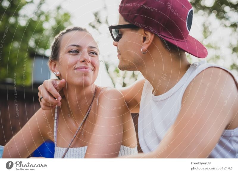 close portrait of a young couple heterosexual caucasian sunglasses hat married romantic romanticism latin outside friends romance male beautiful sitting fun