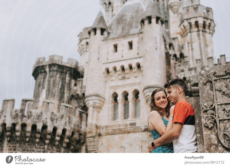 Young couple in front of a medieval castle love two tourists honeymoon young 20s butron tourism travel posing basque country spain hiking princess copy space