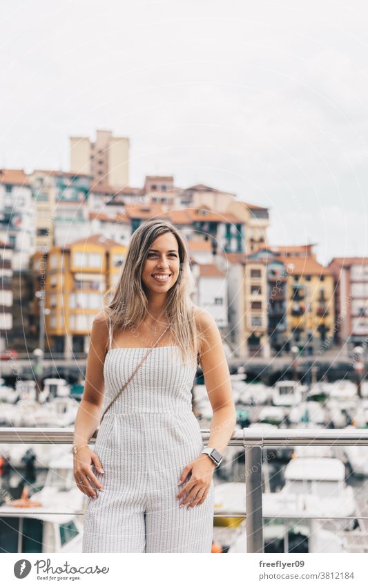 Young woman in front of a small village port young tourist smiling 20s travel portrait tourism posing copy space bermeo pintoresque landscape cityscape colorful