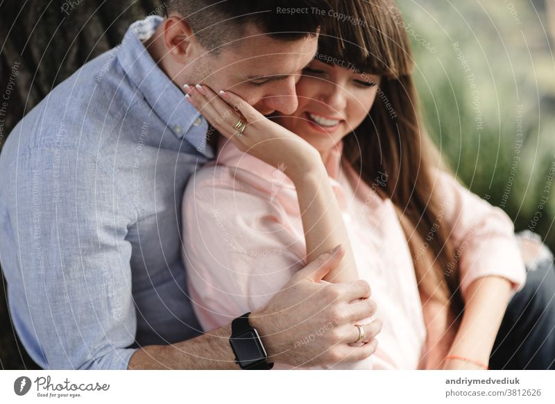 Image closeup of happy cheerful couple in summer clothes smiling and hugging while walking in the park. love story. They kiss and hug each other. selective focus