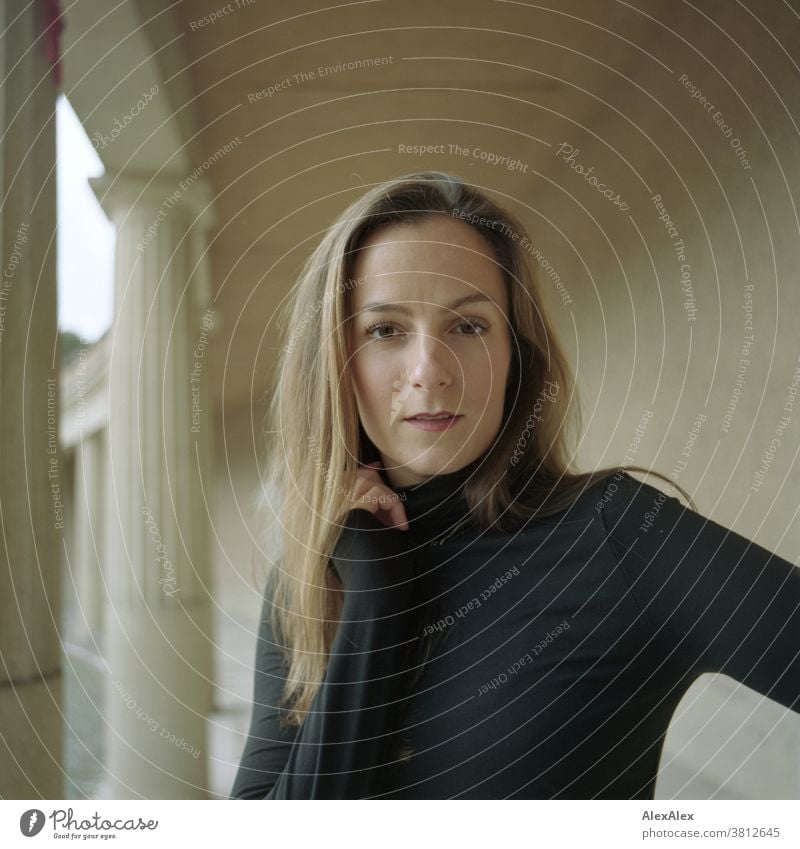 Close portrait of a young woman in a colonnade Woman 18 - 30 years pretty fit Slim smart kind Pleasant Attractive Brunette Long-haired salubriously Fresh teen