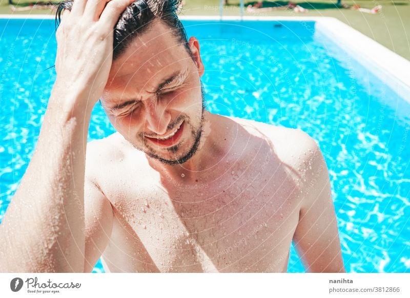 Young handsome man posing near a pool attractive sexy male swimming pool summer skin beard guy smile tan blue water party portrait portraiture real people cool