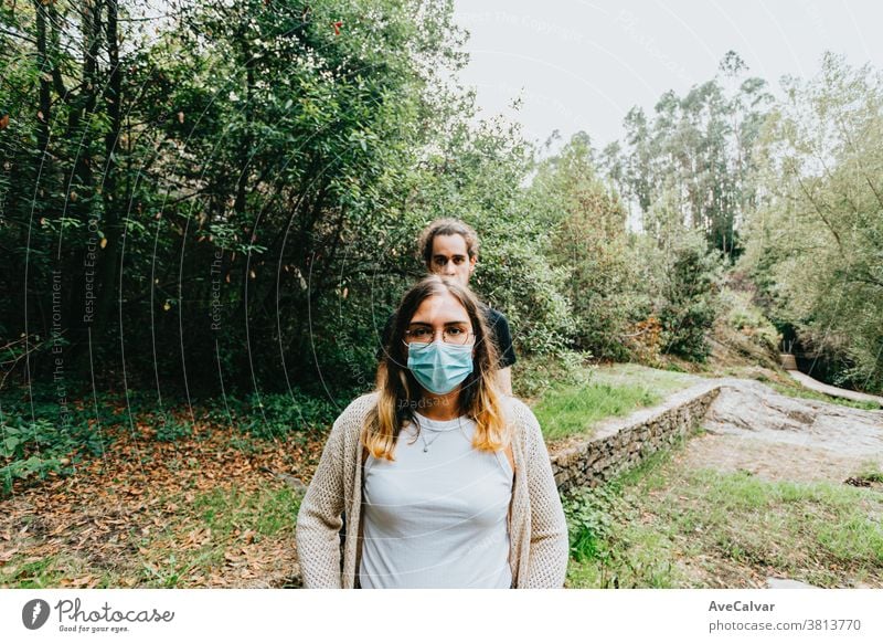 Front shot of a serious couple with the masks put on in the forest photo people mobile communication mobile phone park teenage happy selfie technology fun