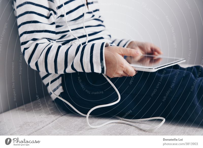 Child with tablet sitting on the floor addiction caucasian child childhood communication computer concept connect connection device digital digital tablet