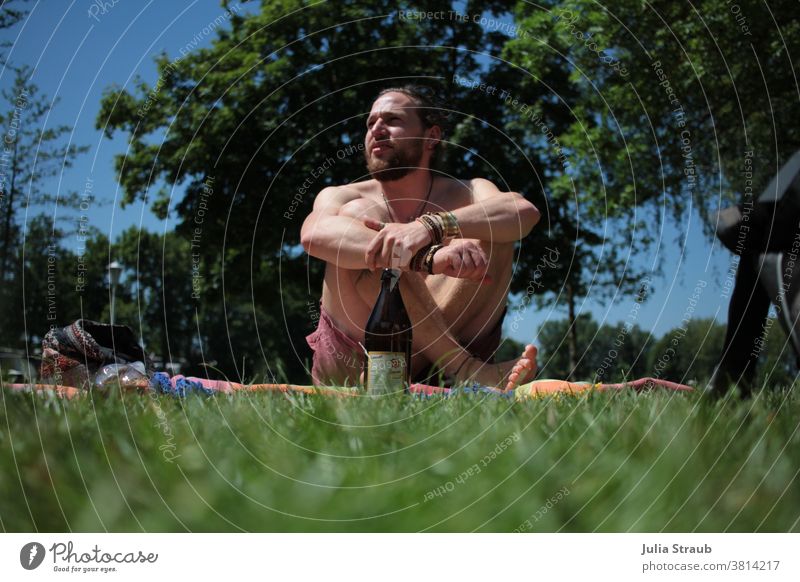 young alternative man with full beard Sits on a blanket in the park in summer Blanket Summer Park Garden chill maintain To talk Beard Braids long hairs youthful