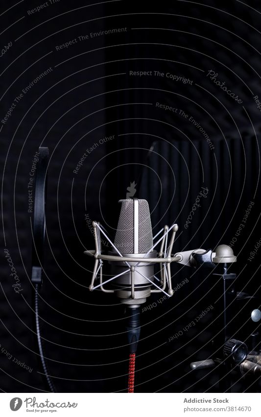 Modern microphone in dark studio record music soundproof foam equipment modern audio professional gadget song melody electronic device metal wire broadcast