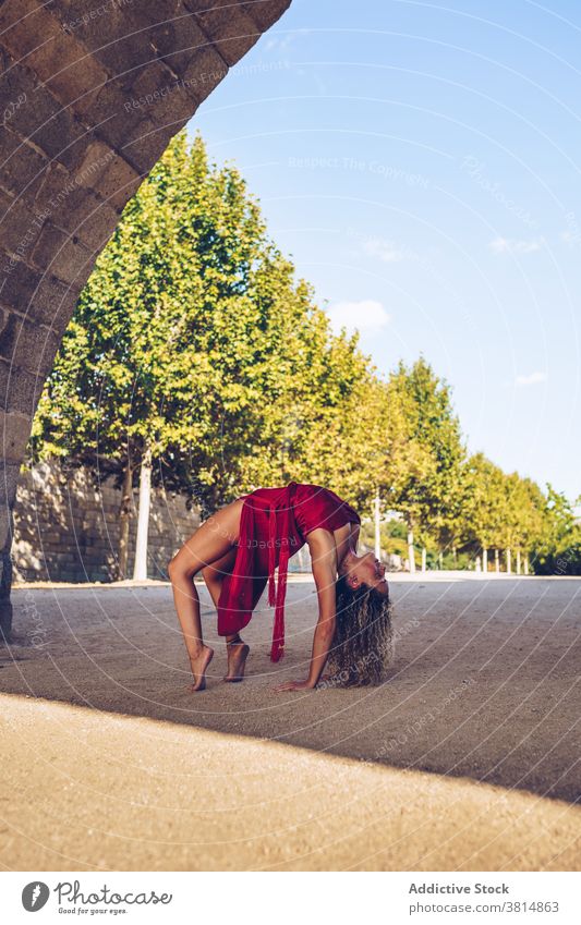 Flexible woman stretching body during yoga practice flexible grace asana wheel urdhva dhanurasana balance slim arch pose position female wellness harmony