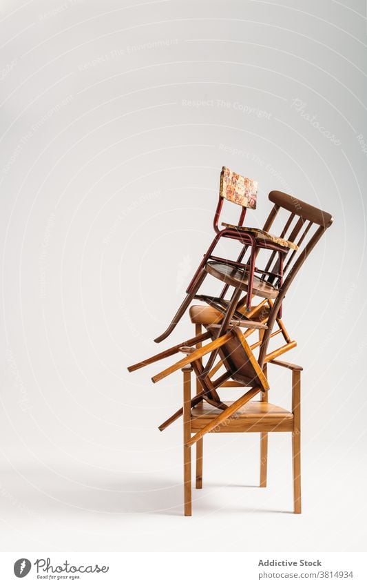 Set of old chairs stacked against white background furniture pile messy disordered seat wooden old-fashioned classical hipster minimal simplicity copy space