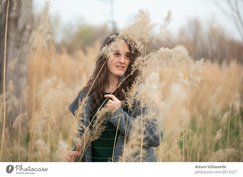 portrait of a woman surrounded by reeds. He is wearing a gray jacket. abstract adult asian background backlight beautiful beauty brunette chinese cute elegance