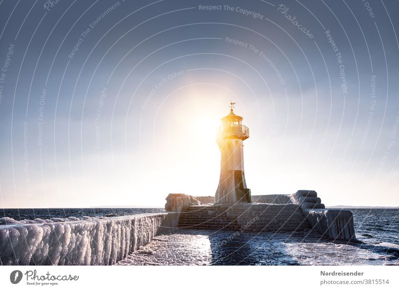 Iced pier with lighthouse of Saßnitz in winter Back-light Sunbeam Sunlight Light Reflection Light (Natural Phenomenon) Copy Space top Copy Space right