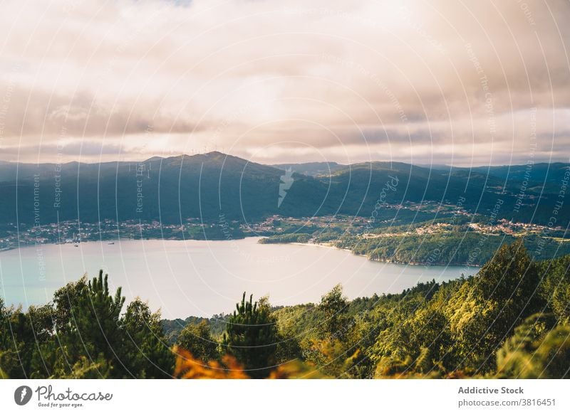 Scenery of lake in mountainous terrain sunset landscape pond scenery nature cloudy calm sunlight evening idyllic water hill peaceful dusk majestic highland area