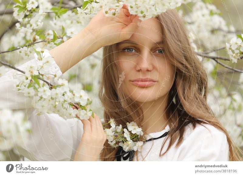 portrait of a happy girl in spring flowers. A beautiful young girl with flowers bouquet near a floral wall. hair summer healthy cute dress nature woman romance