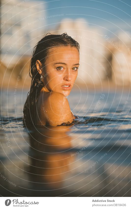 Young woman in sea water in summer wet hair sunset ocean enjoy weekend vacation carefree rest holiday nature evening dusk smile idyllic recreation tourism trip