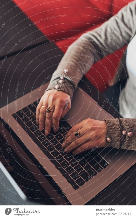 Woman working remotely on her laptop computer managing her work sitting in a cafe business caucasian coffee connection contemplate desk entrepreneur female