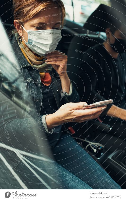 Woman talking on phone using smartphone sitting in a car wearing the face mask to avoid virus infection caucasian covid-19 lifestyle outbreak pandemic woman