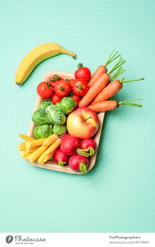 Vegetables in a plastic-free package, palm leaf tray, isolated on a green background. above view alternative box containers cut out diet dieting dish