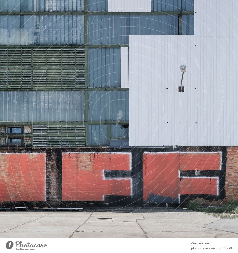 Wall of a factory in white and grey with red graffiti Factory Wall (building) Graffiti White Woman Glass blinds Corrugated sheet iron Town urban Decline