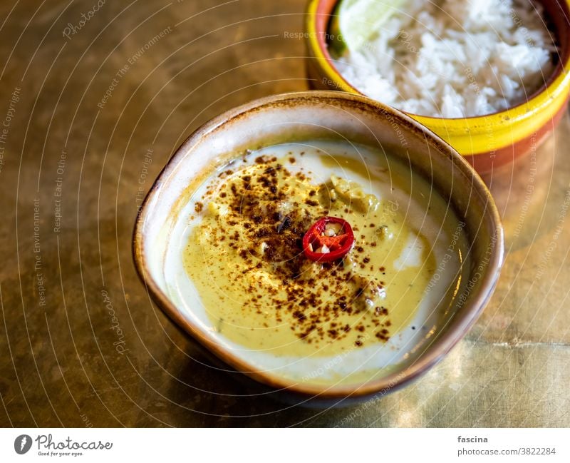 Yellow curry with cauliflower and chickpea yellow rice metal tabletop background indian food restaurant copy space text design asian copy space left vegetarian