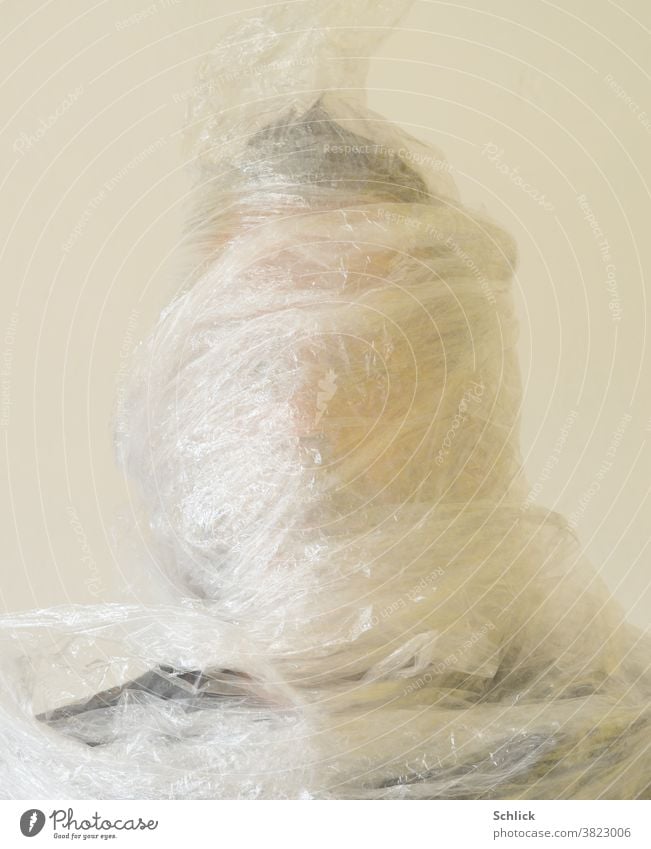 Plastic mania Head of a man wrapped in stretch foil Packing film plastic portrait Wrapped around Man stretch film Environmental protection plastic waste Trash