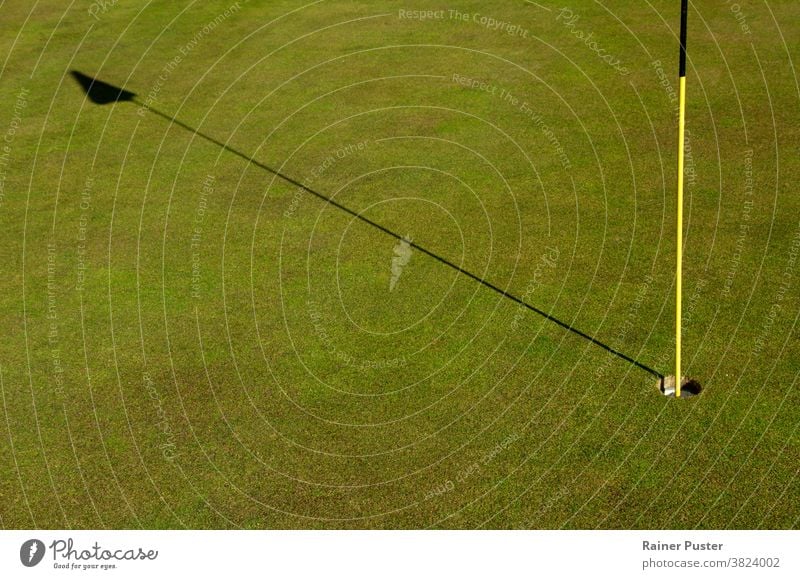 Close-up of hole and flag stick on a golf course birdie close up club copy space daytime fairway field game garden golf club golf flag golf hole golfing grass