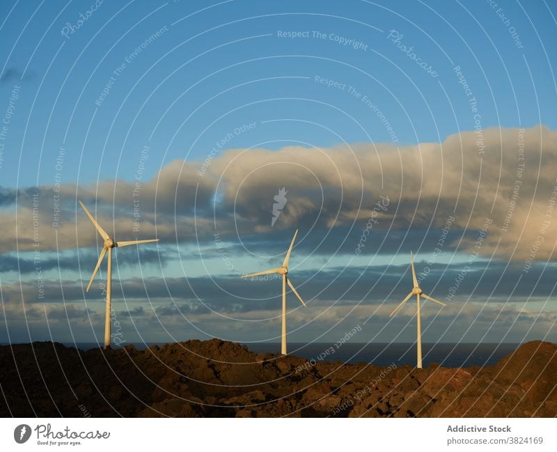 Amazing view of windmills in countryside at sunset alternative energy resource sustainable eco friendly development sea hill modern scenic ecology renewal