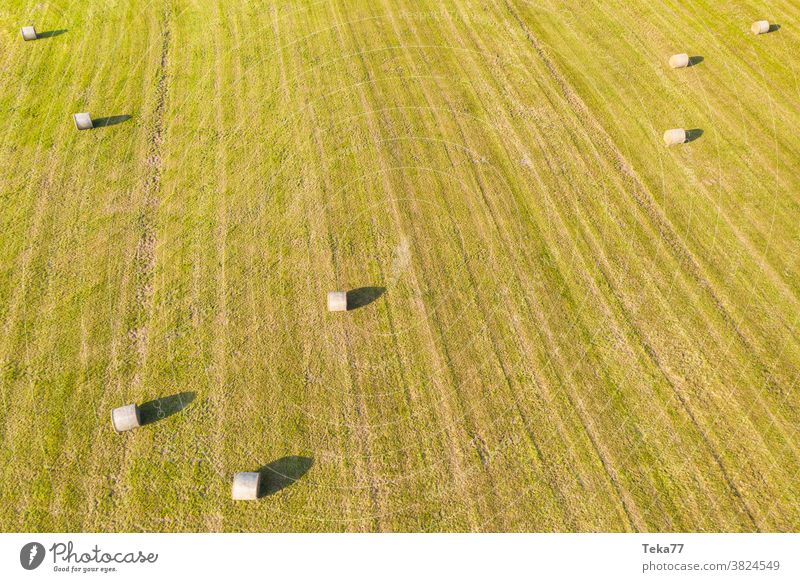 a large meadow with hay bales from above farming farm grounds grass tractor food animal sunny