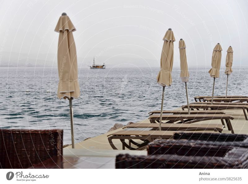 Boat in front of the pier after the rain. Boat sea Ocean ship Water travel Sky Sunshade deckchairs Beach chair