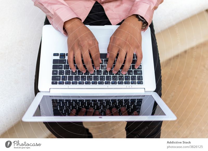 Anonymous businessman working on the compute in city celebrate typing laptop male ethnic black african american entrepreneur project professional street hands