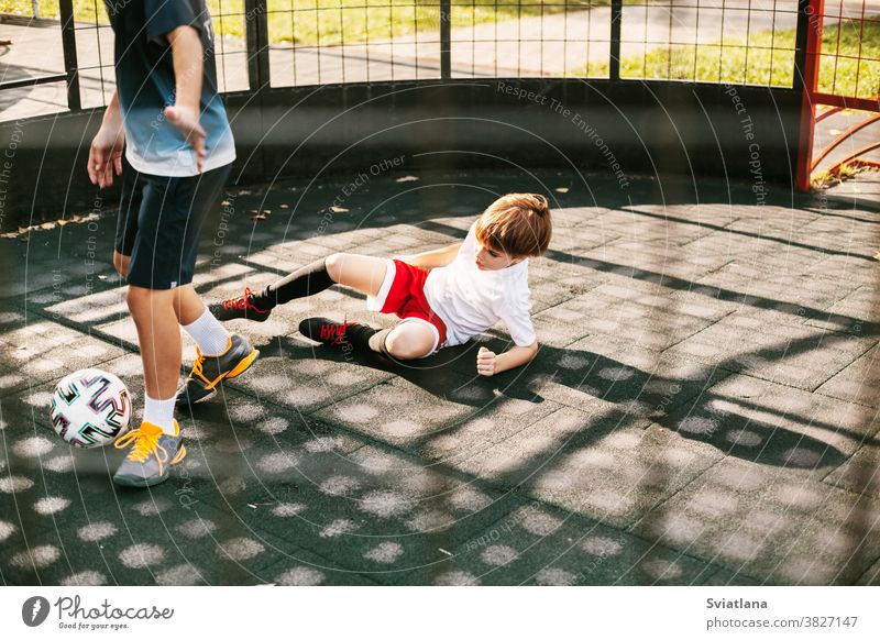 Boys play soccer on the freestyle soccer field. Boys fight for the ball in the game. Sport, game, competition, football freestyle player playing boy two