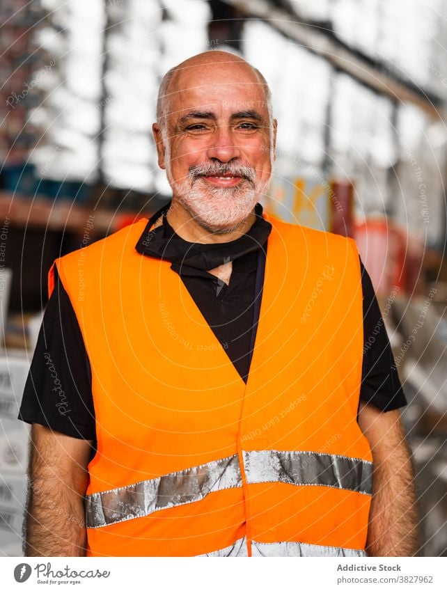 Male warehouse employee in uniform standing near rack in warehouse man worker professional at work storage storehouse workplace industry calm focus industrial