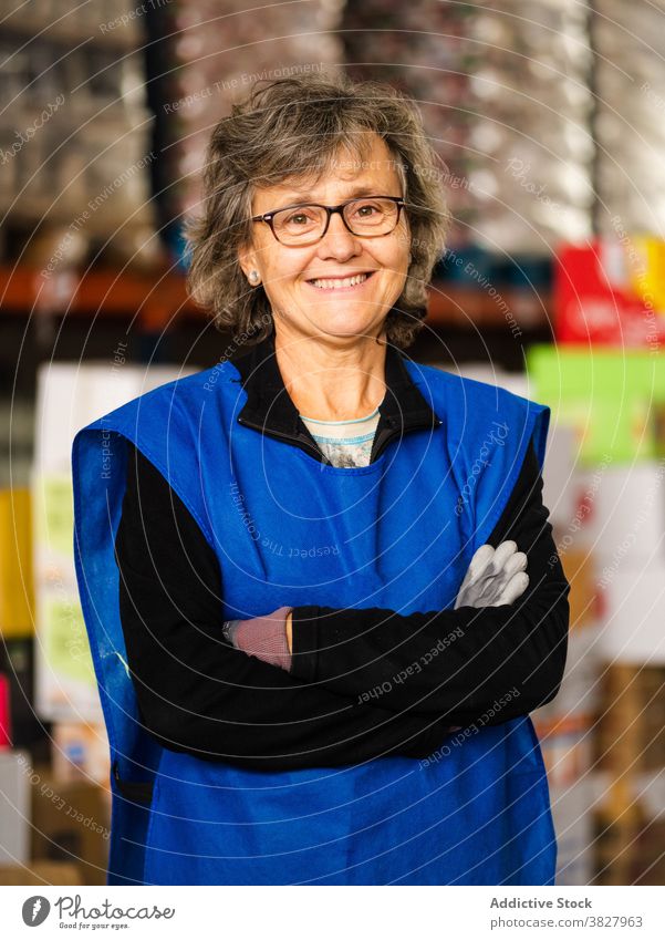 Cheerful female worker standing with crossed arms in storehouse woman cheerful toothy smile job employee at work workspace staff confident portrait arms crossed