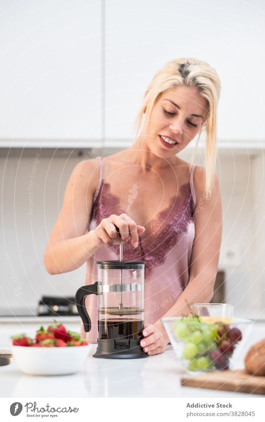 Woman preparing coffee for breakfast french press coffeemaker woman home kitchen early pajama prepare female counter silk beverage drink aromatic fresh brew