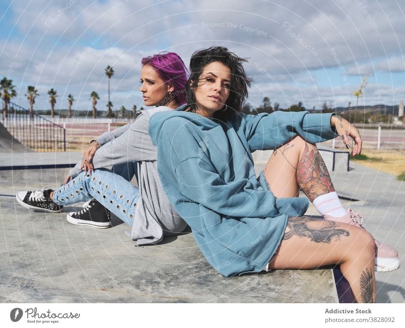 Stylish women in skate park in summer pink hair informal friend millennial hipster together tattoo appearance urban street eccentric friendship content