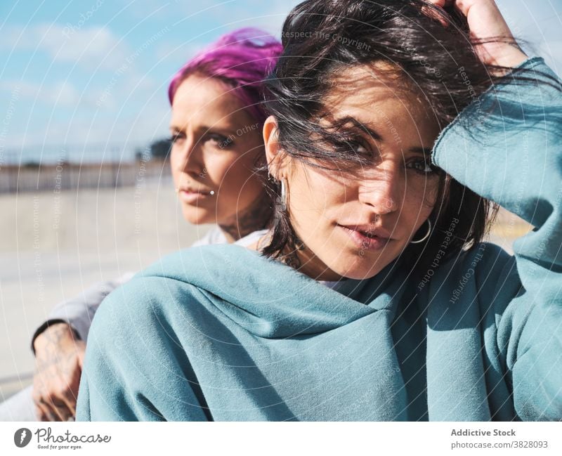 Stylish women in skate park in summer pink hair informal friend millennial hipster together tattoo appearance urban street eccentric friendship content